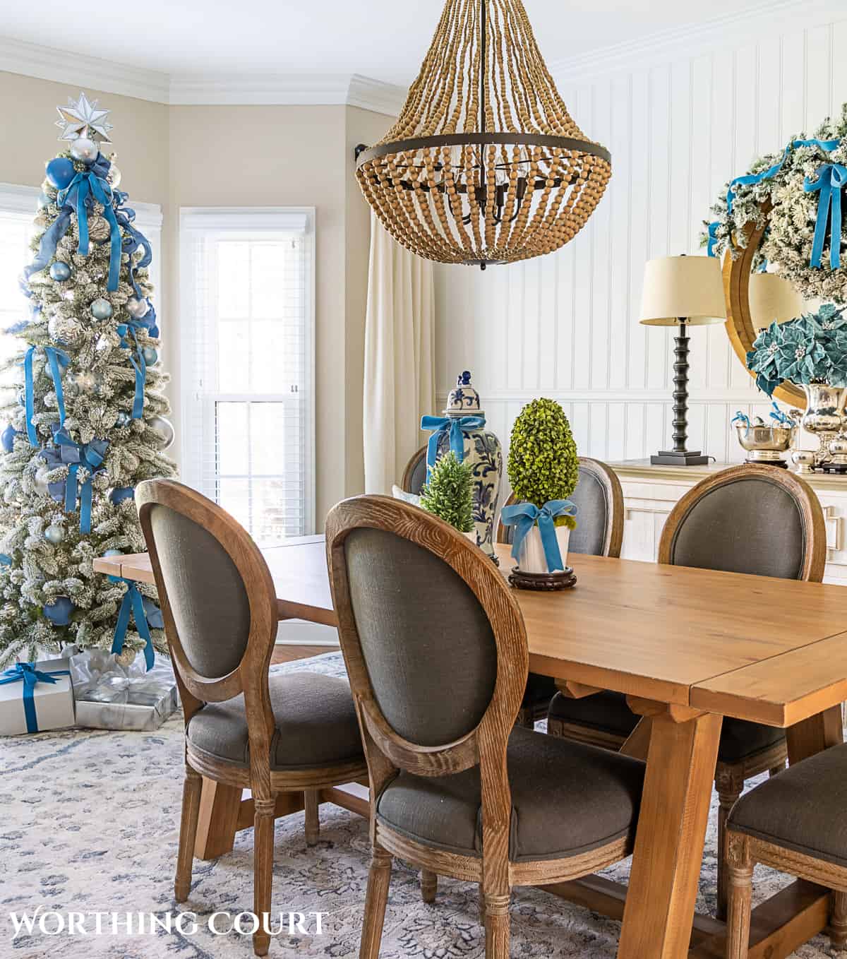 dining room decorated for Christmas with French blue and silver with a flocked Christmas tree