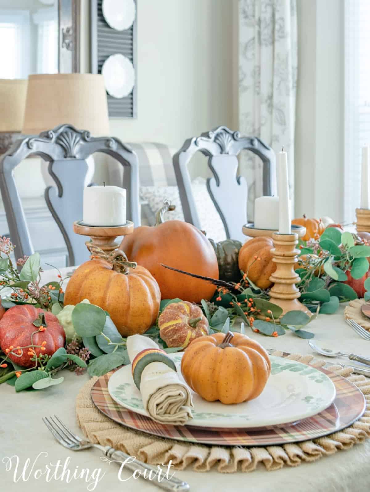 portion of thanksgiving tablescape with fall colors and eucalyptus in the centerpiece