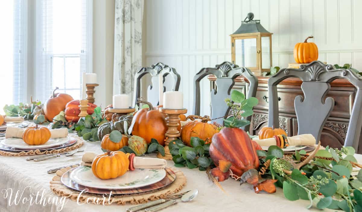portion of thanksgiving tablescape with fall colors and eucalyptus in the centerpiece