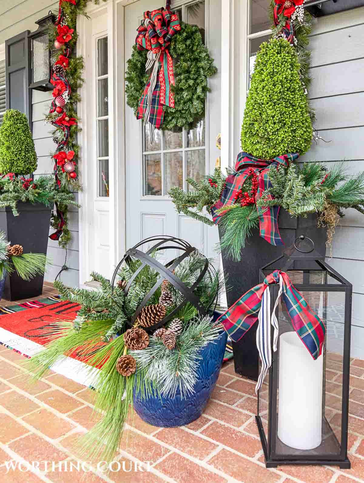 Front porch decorated for Christmas with red and green decorations