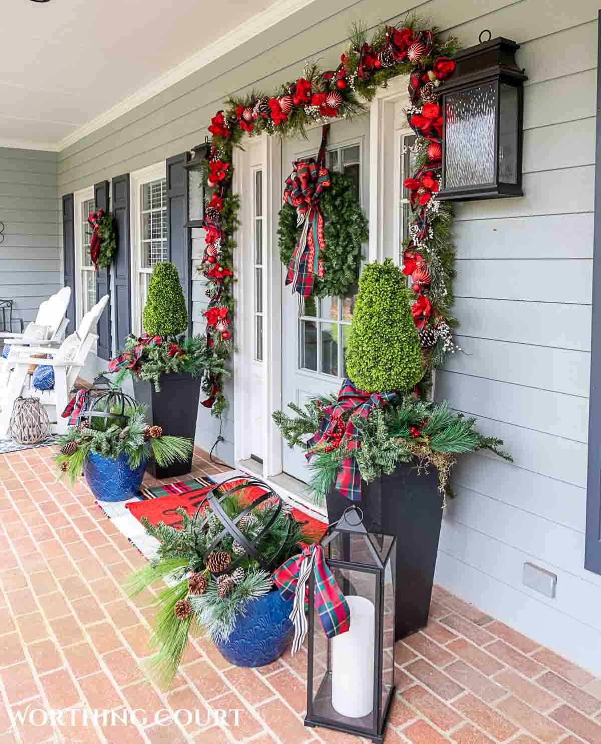 Front porch decorated for Christmas with red and green decorations