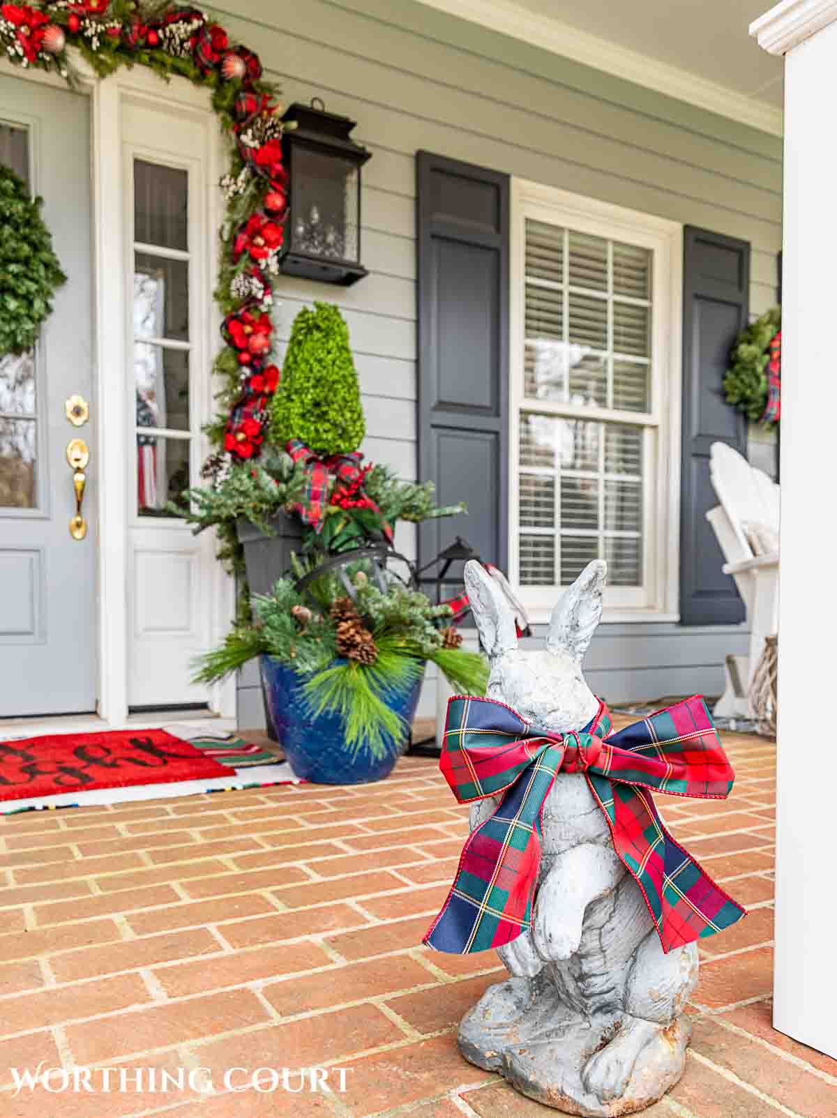 Front porch decorated for Christmas with red and green decorations