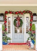 Front porch decorated for Christmas with red and green decorations