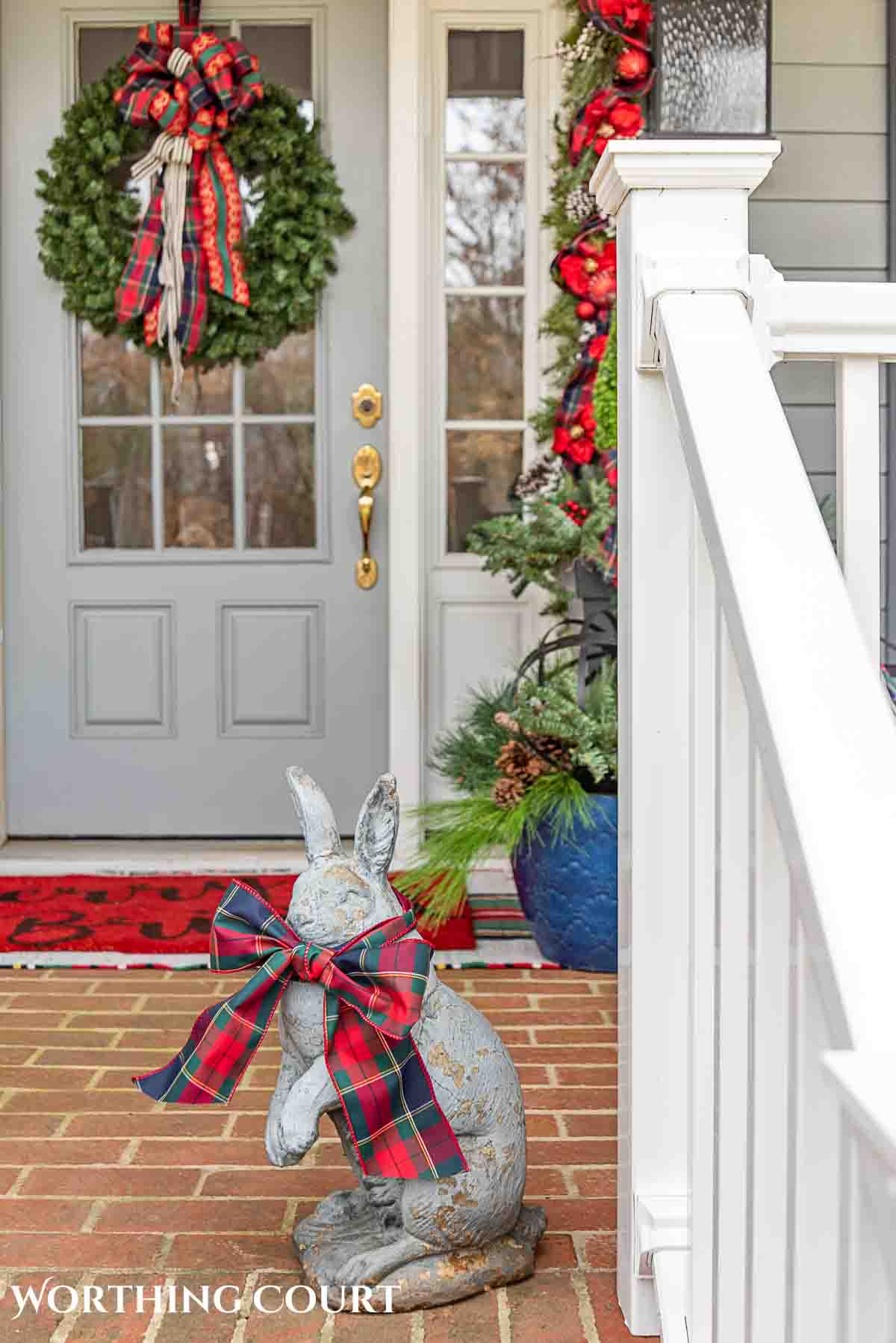 Front porch decorated for Christmas with red and green decorations