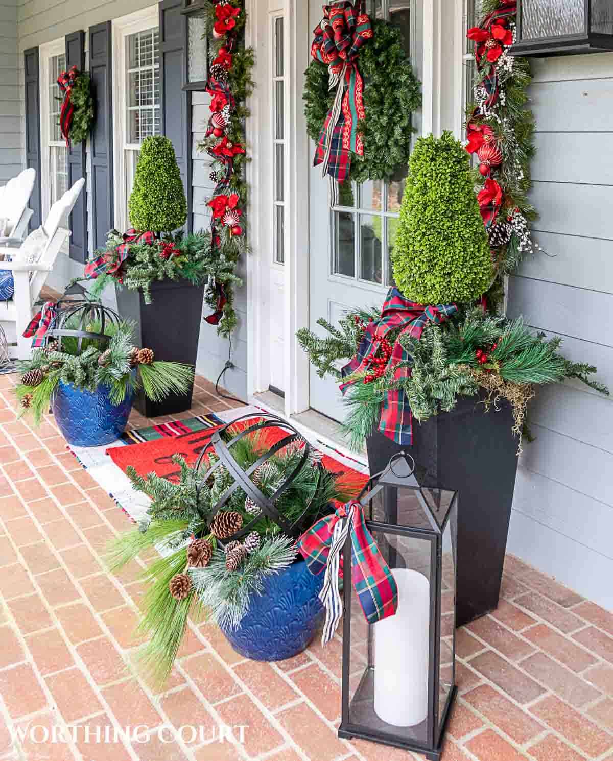 Front porch decorated for Christmas with red and green decorations