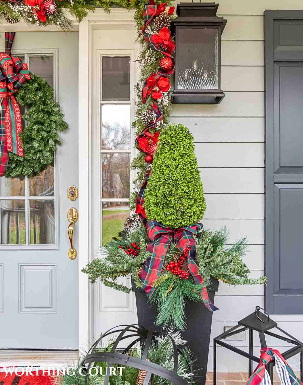 Front porch decorated for Christmas with red and green decorations