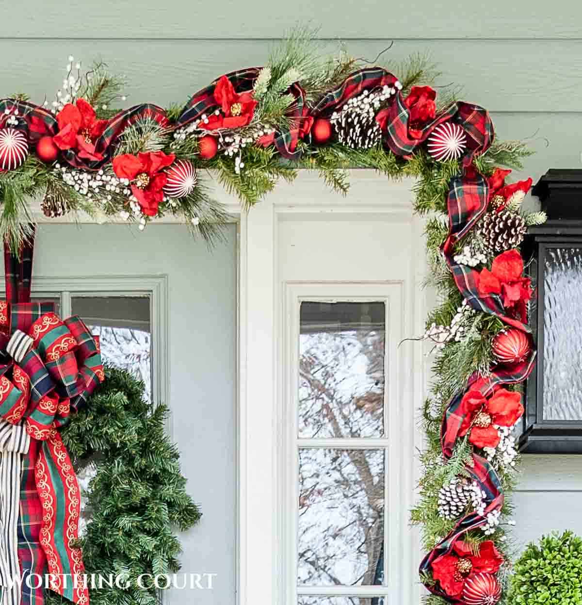 Front porch decorated for Christmas with red and green decorations