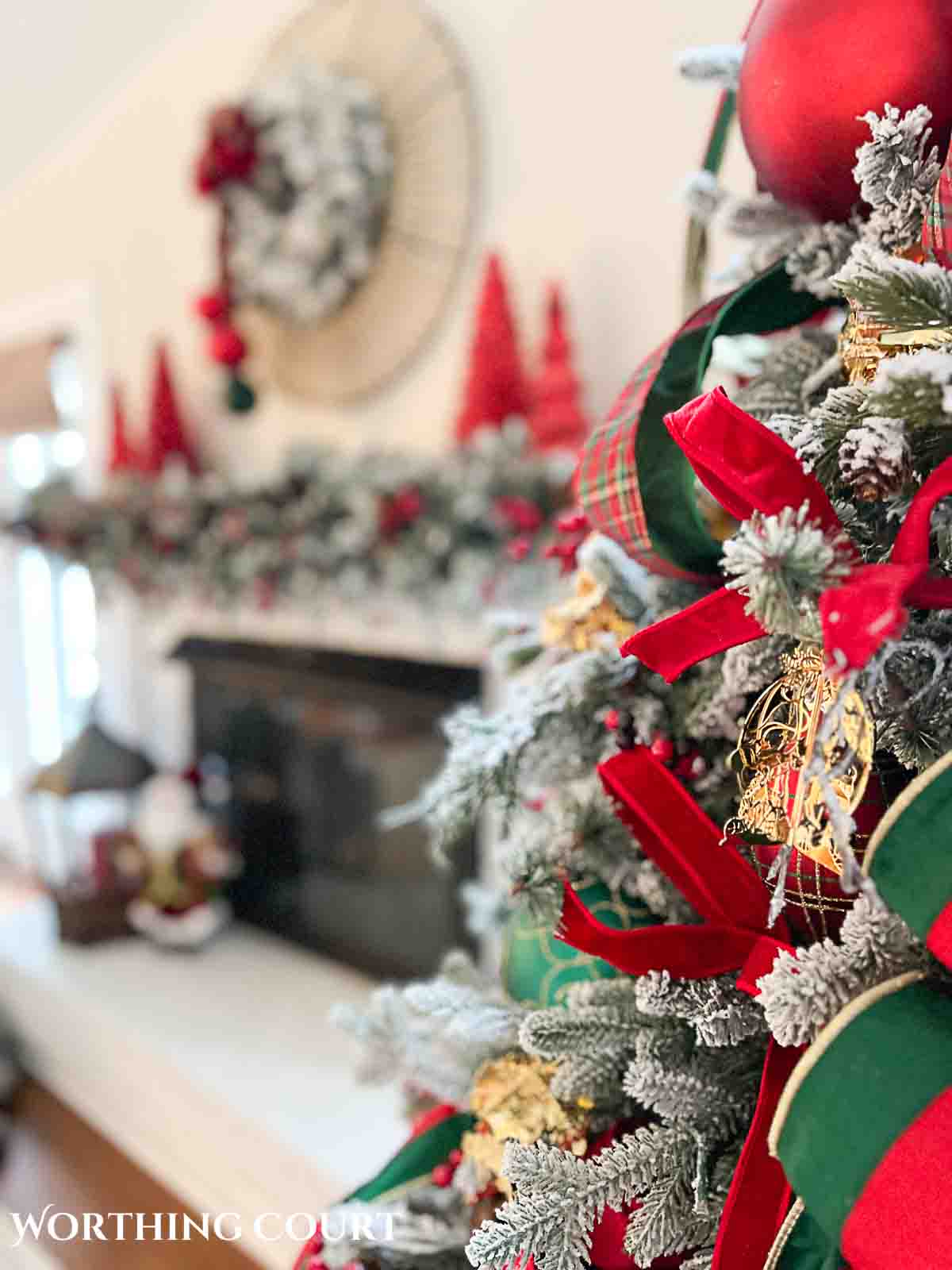 Christmas tree, fireplace and living room decorated for Christmas with red green and gold decorations