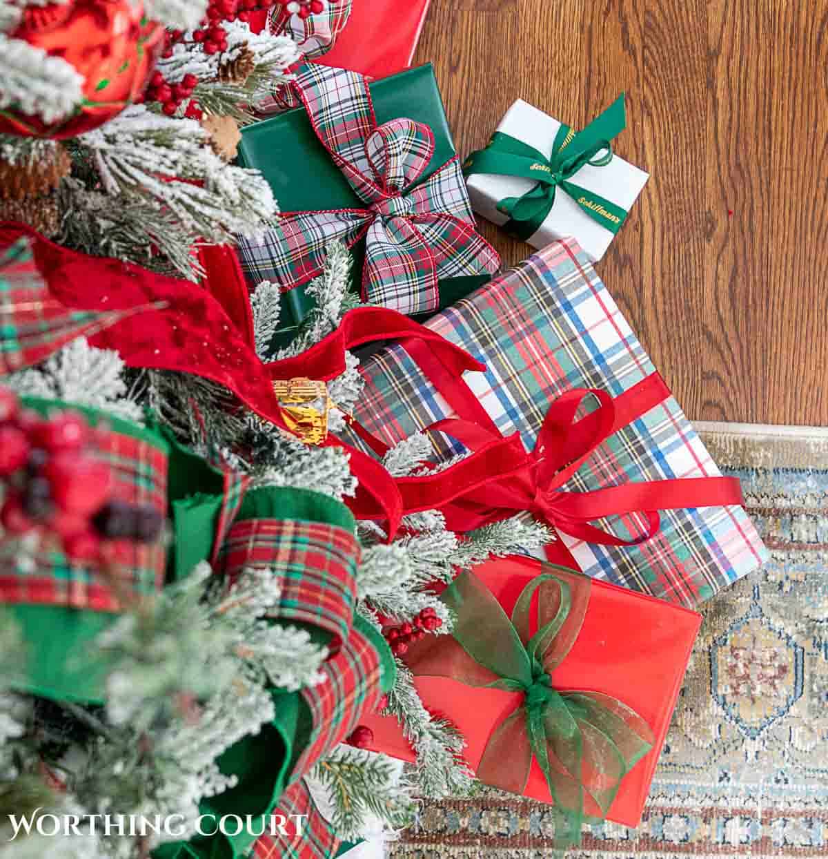 Christmas tree, fireplace and living room decorated for Christmas with red green and gold decorations