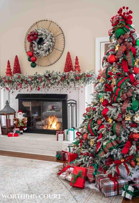 Christmas tree, fireplace and living room decorated for Christmas with red green and gold decorations