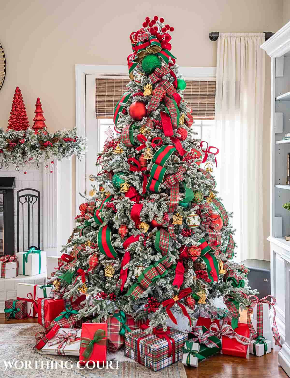 Christmas tree, fireplace and living room decorated for Christmas with red green and gold decorations