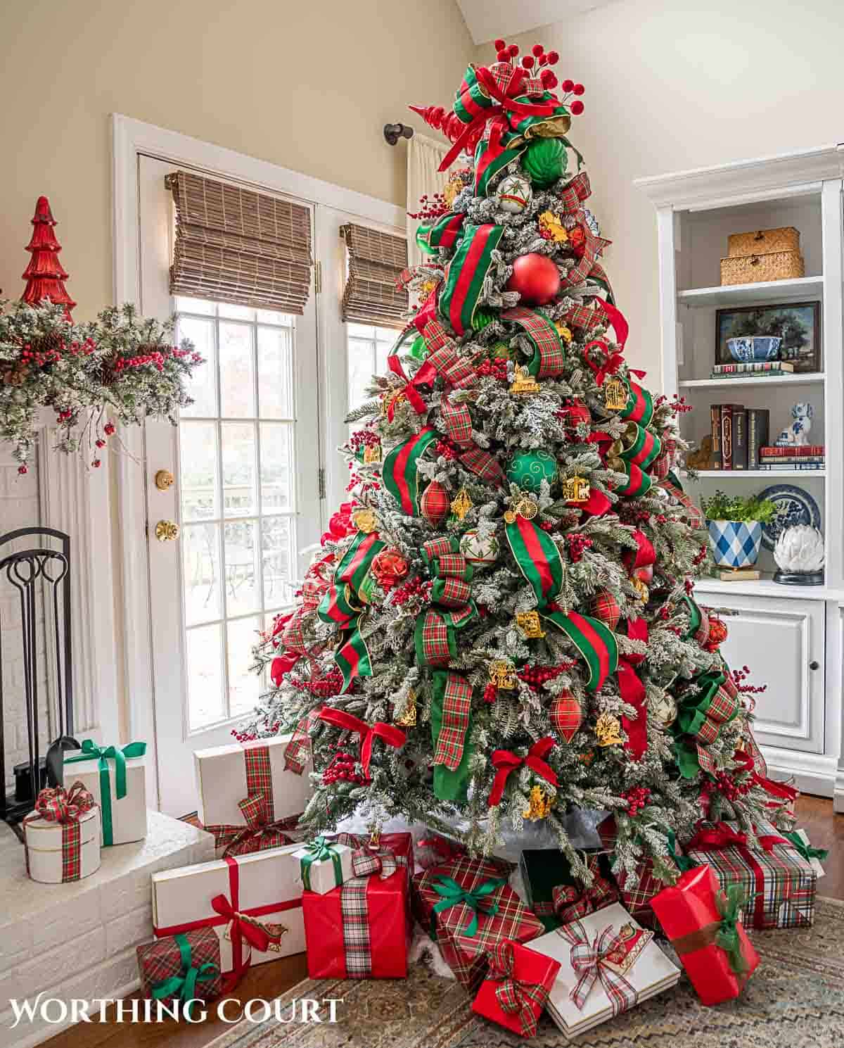 Christmas tree, fireplace and living room decorated for Christmas with red green and gold decorations