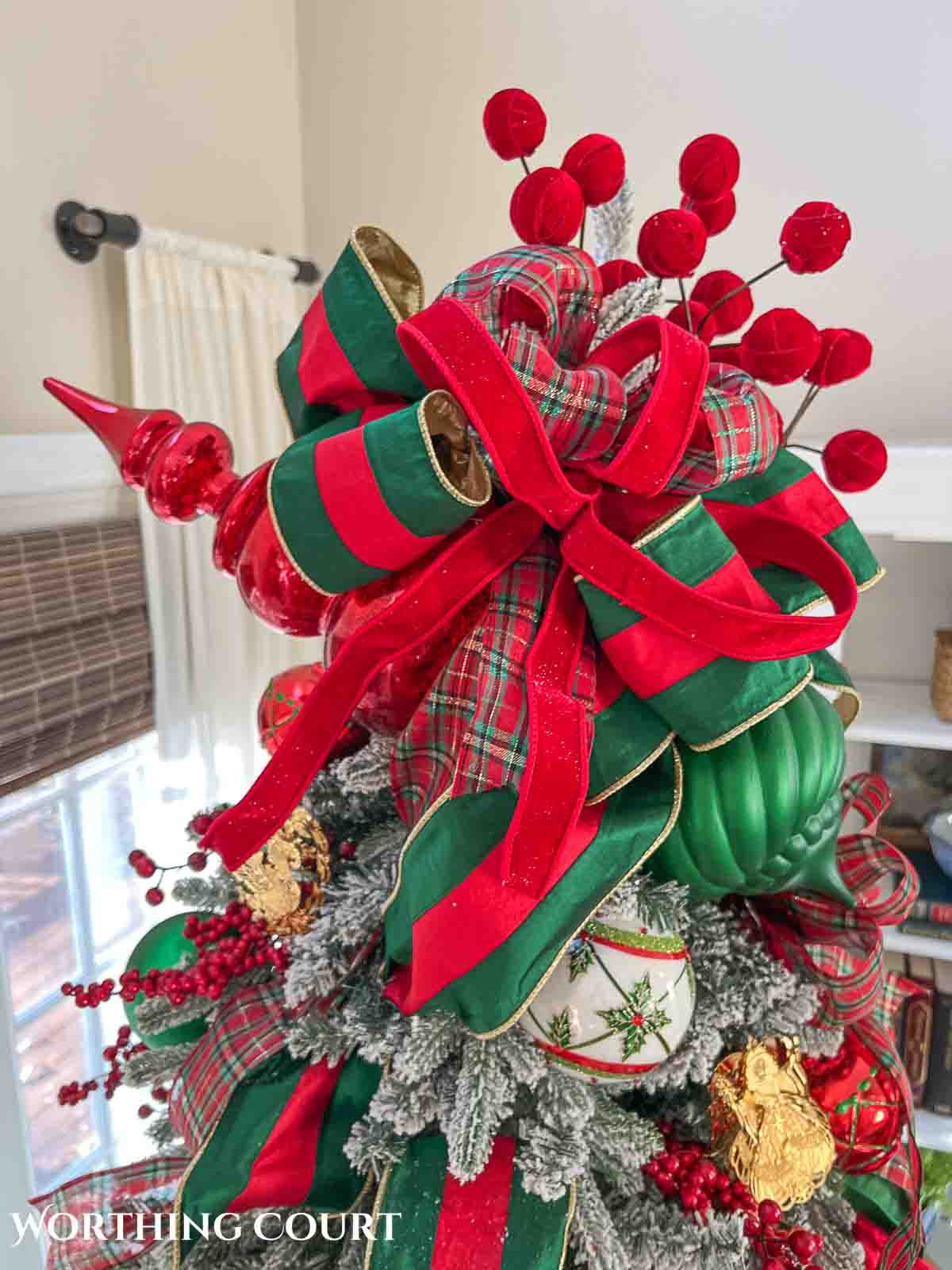 Christmas tree, fireplace and living room decorated for Christmas with red green and gold decorations