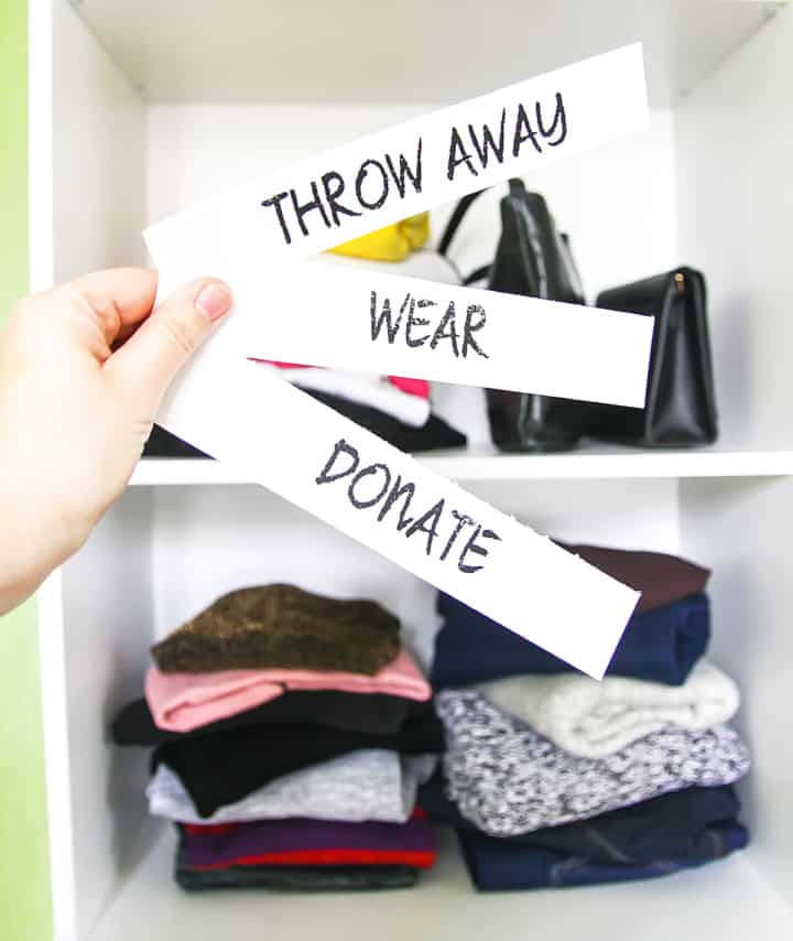 clothes in stacks of what to throw away, keep or donate before organizing a closet