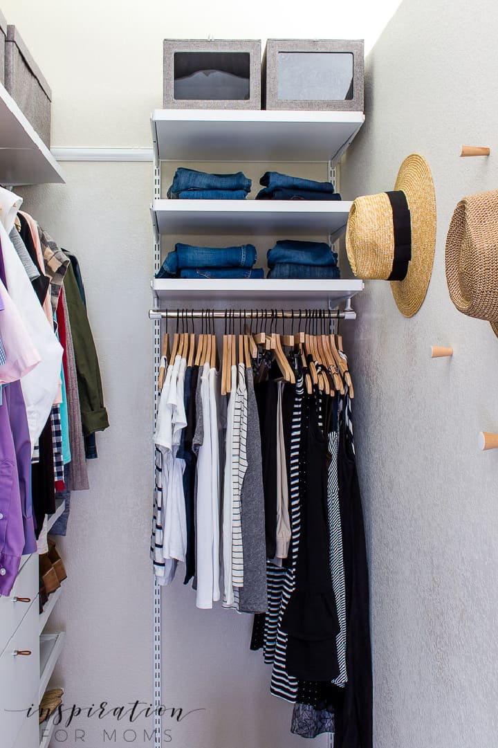 a small closet organized with extra shelves and hanging space in a small nook