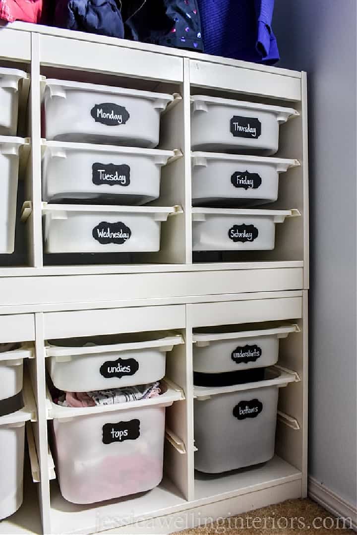 plastic bins in a small closet labeled with what's inside