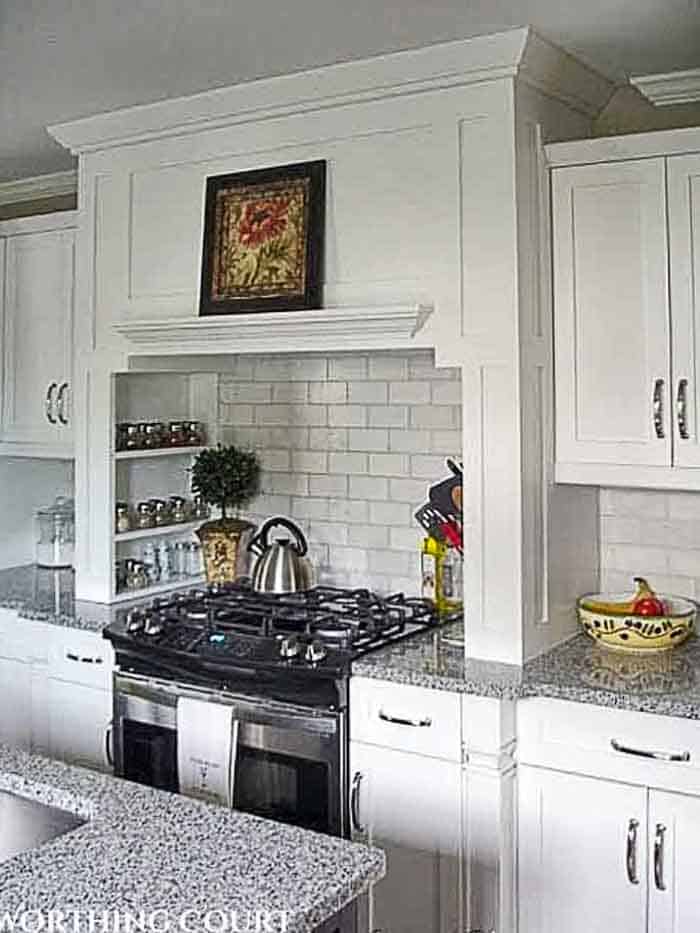 range with hood in a kitchen with white cabinetry