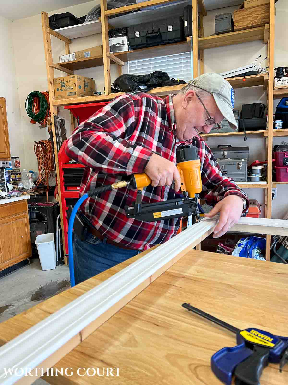man using a nail gun to make a canvas art frame