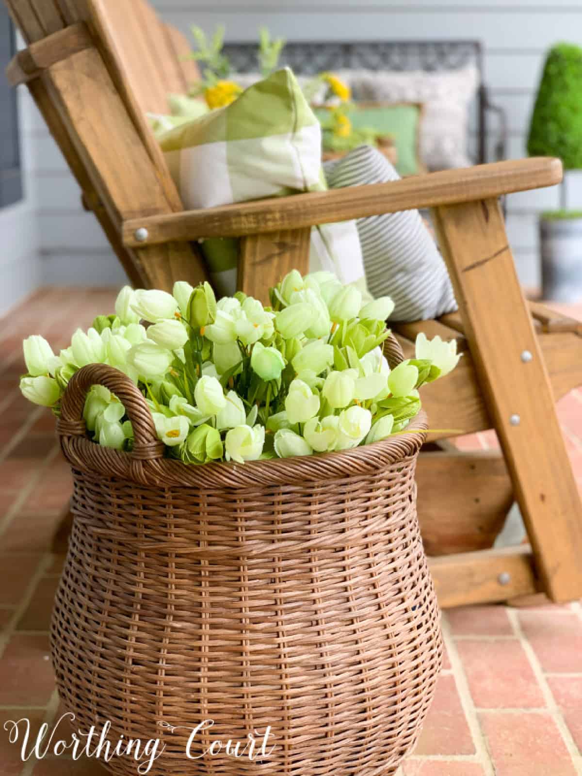 basket filled with faux tulips as part of spring porch decorations