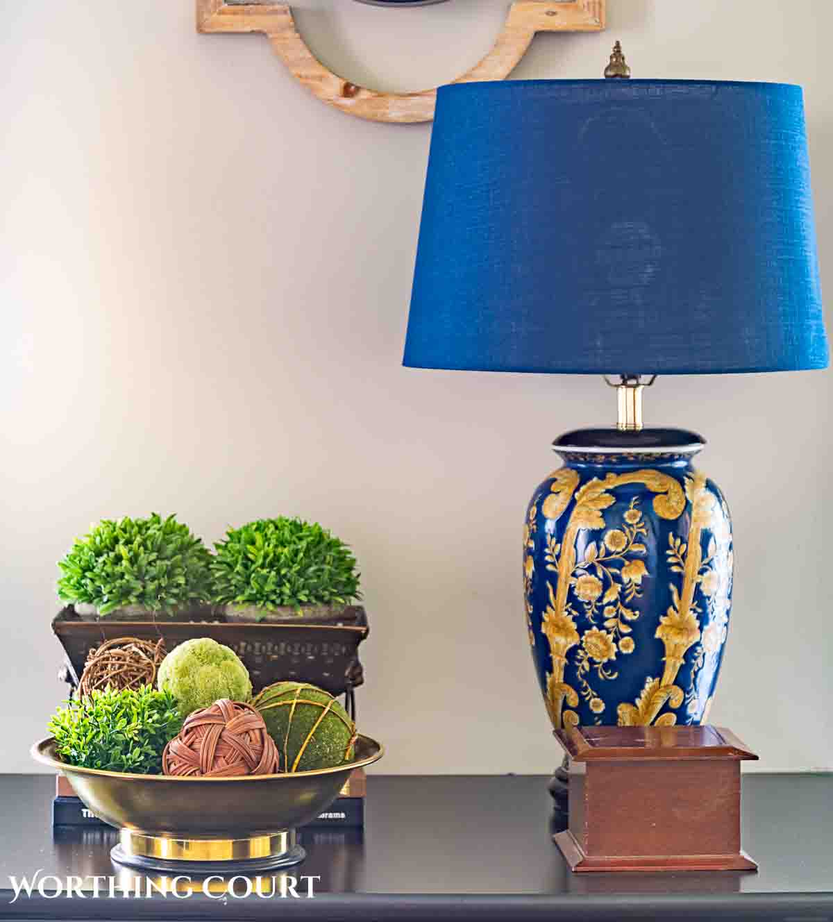blue lamp greenery and other accessories on a black chest for spring
