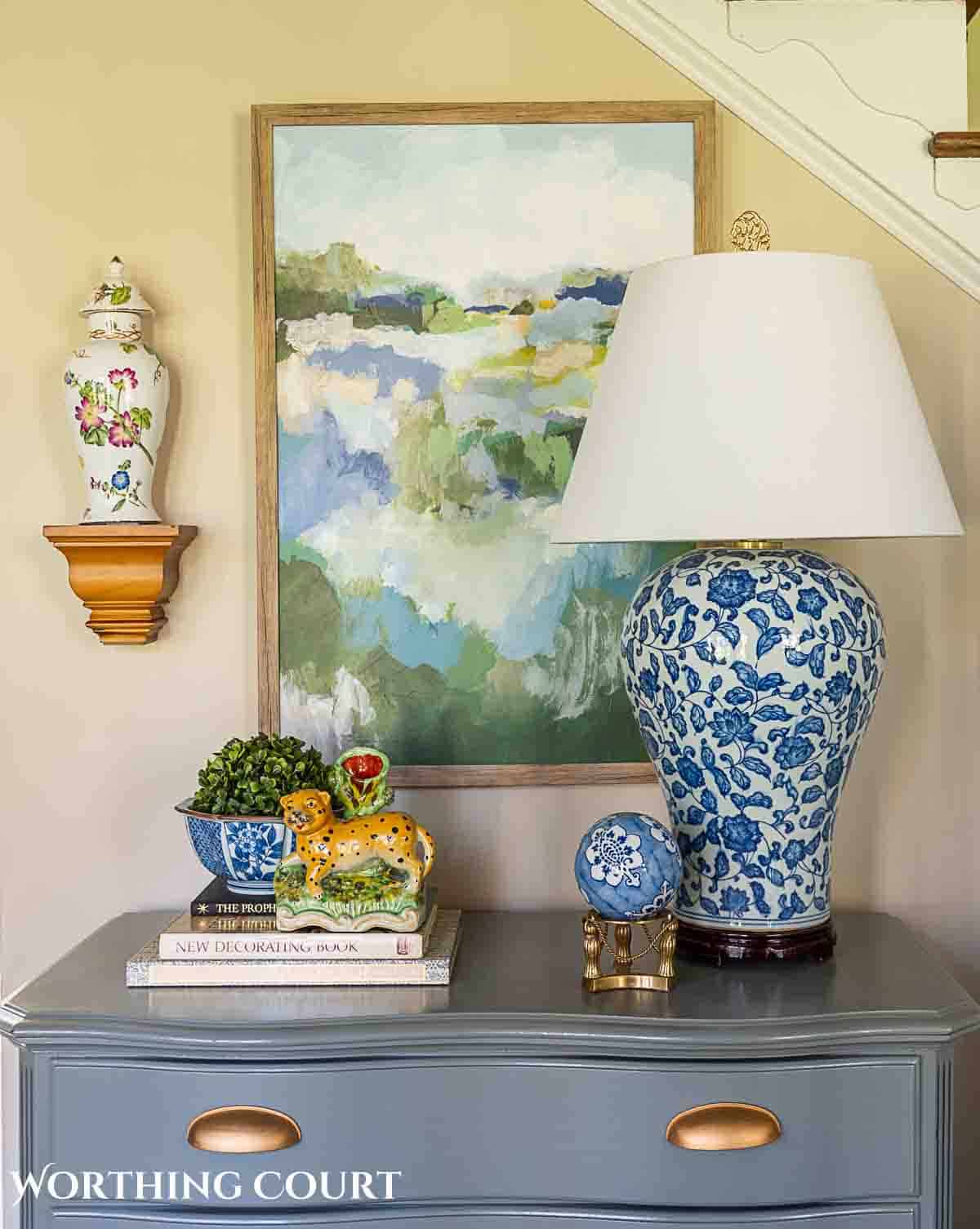 spring greenery and blue and white accessories on a gray chest