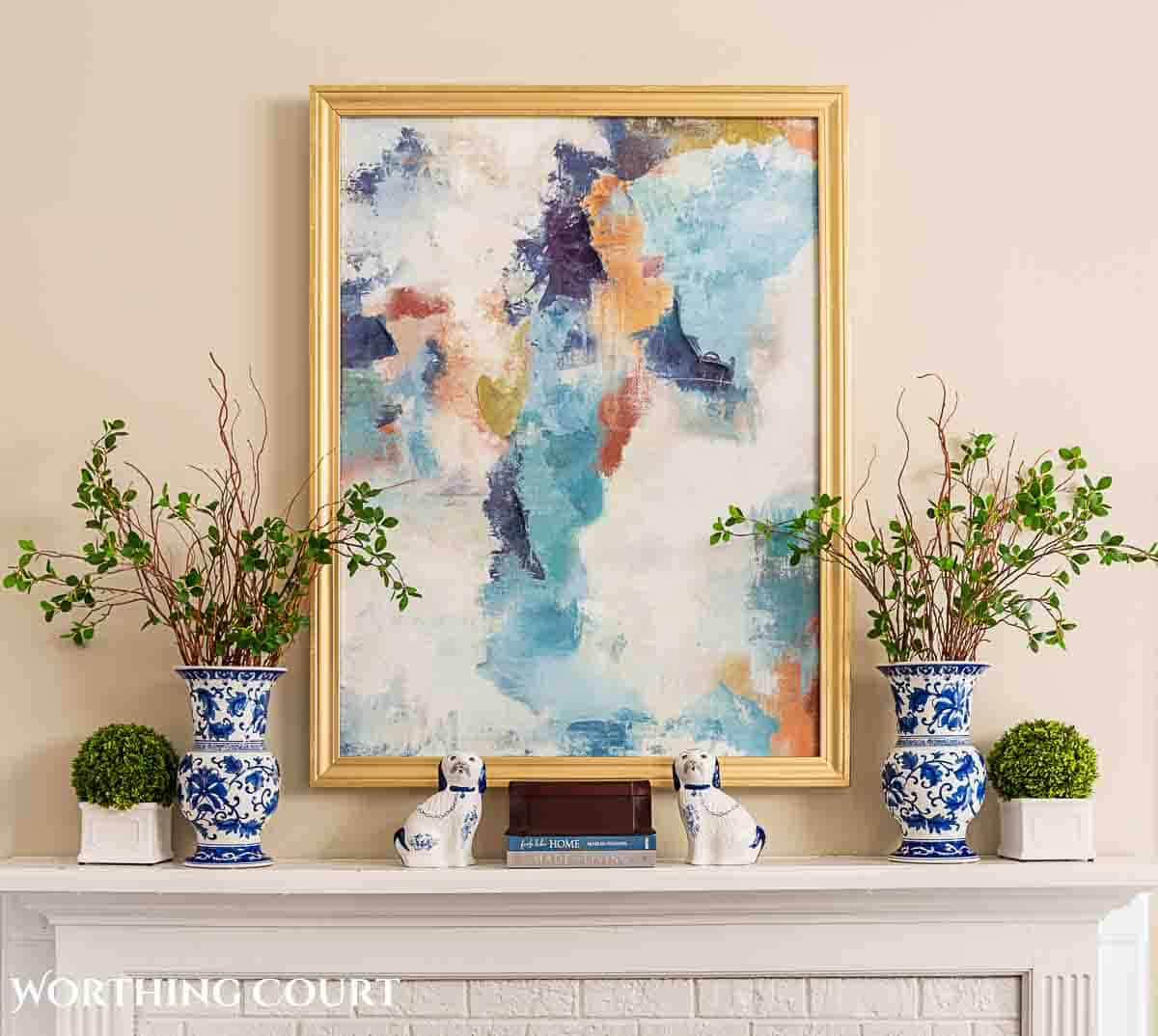 abstract art and spring decor on a white mantel