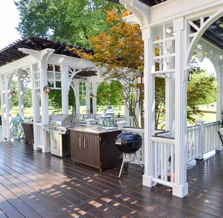 brown deck with white pergola type structures on it to create zones