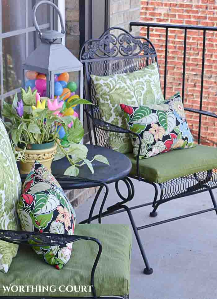 metal outdoor chairs with green cushions and colorful pillows