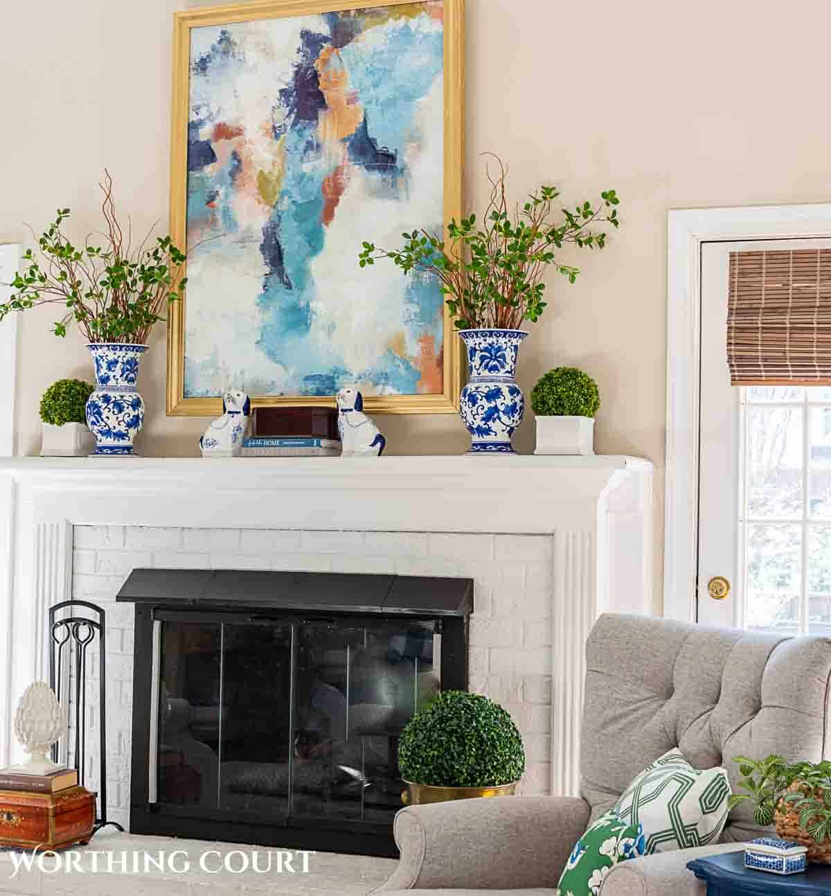 mantel decorated with abstract wall art above it and blue and white spring decor