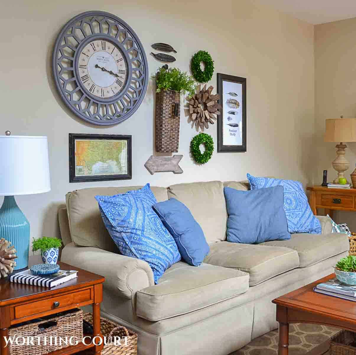 beige sofa with blue pillows and gallery wall decor