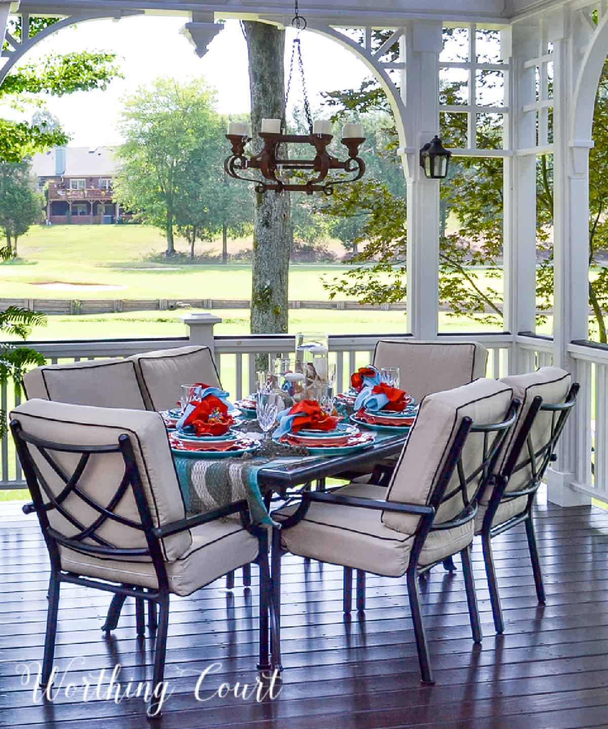outdoor dining area on a deck with a turquoise and coral tablescape