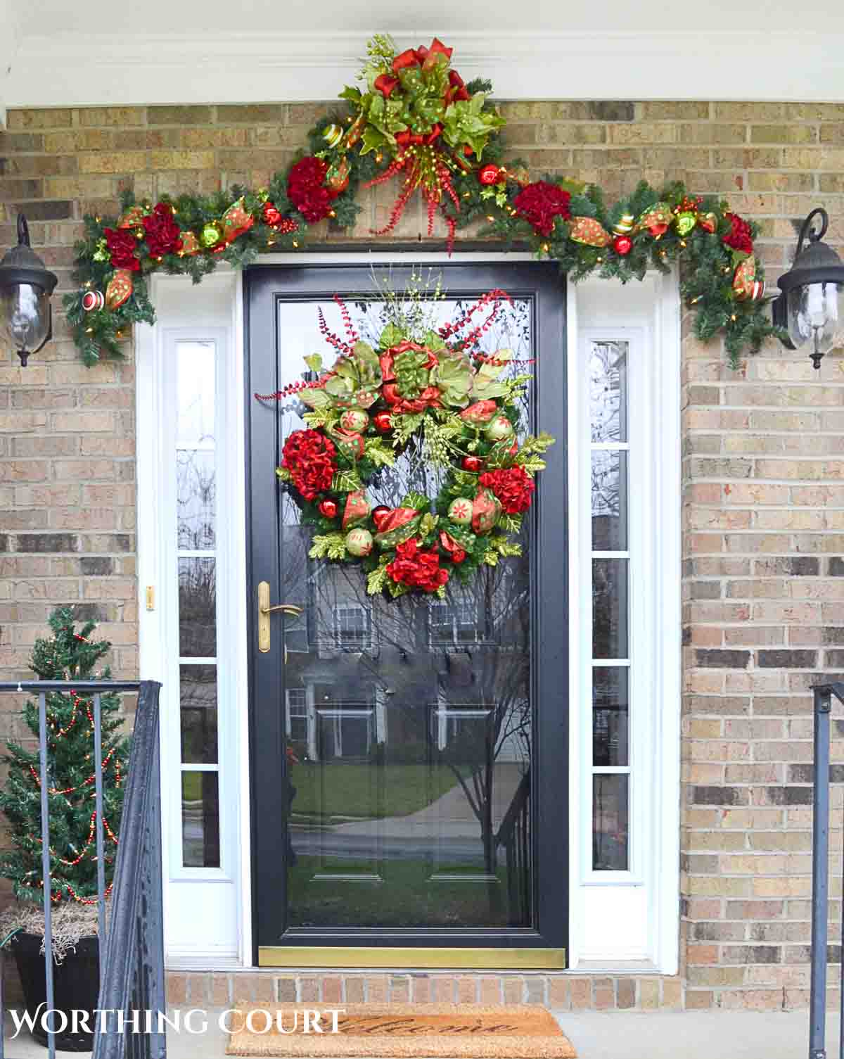 Christmas garland and wreath on a front porch with red hydrangeas