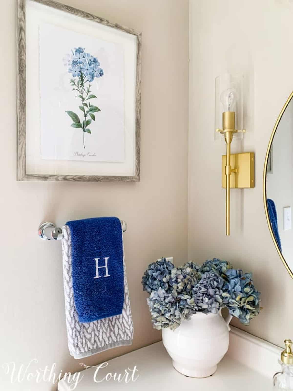 blue hydrangea arrangement in a white vase on a bathroom vanity