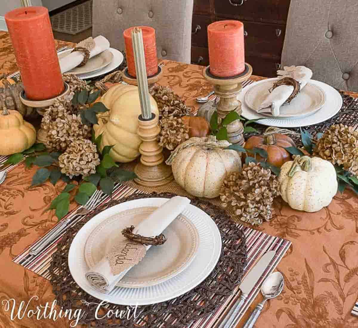 Thanksgiving table setting with pumpkins and hydrangeas in the centerpiece