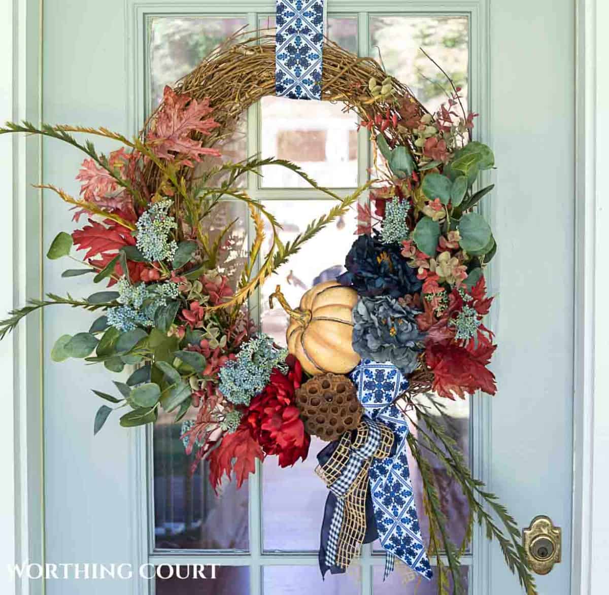 fall wreath with burgundy hydrangeas and other blue flowers and greenery