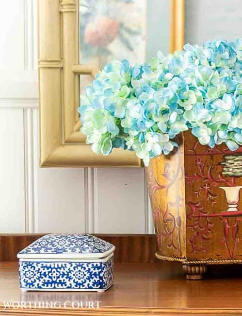 partial image of blue hydrangeas in a brown metal container beside a blue and white porcelain box