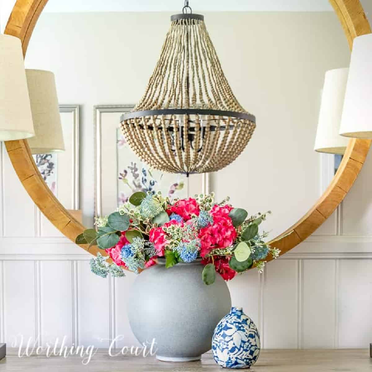 gray vase with hydrangea flower arrangement in front of miiror