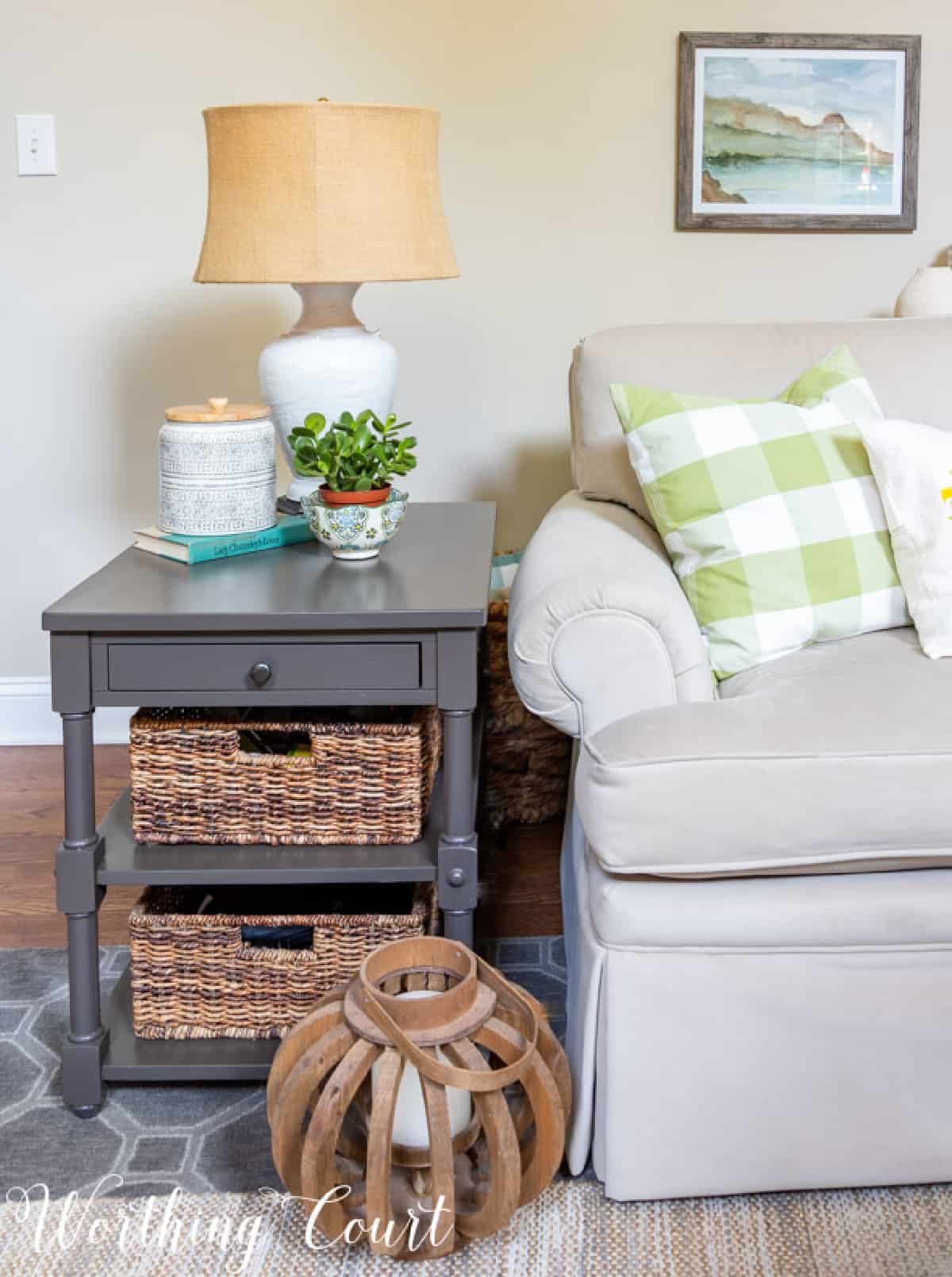 gray end table with baskets on shelves that give off a coastal style vibe