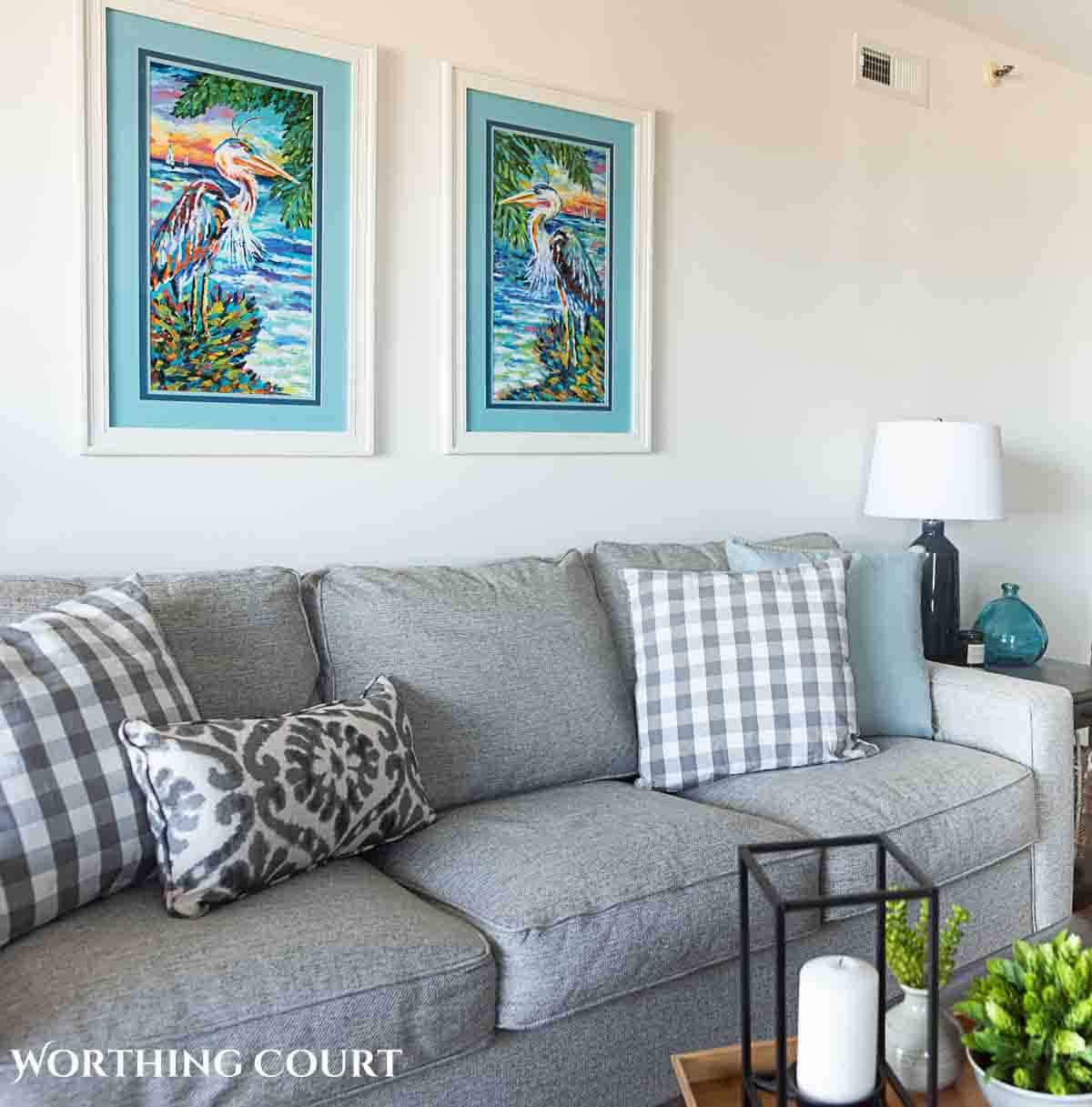 colorful coastal artwork above a gray couch