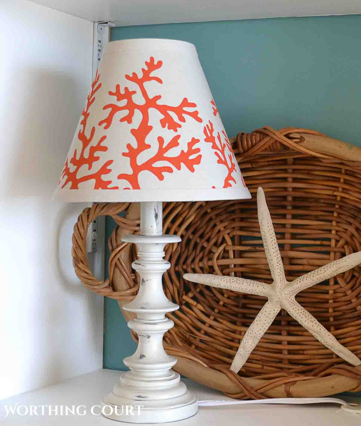 small white lamp with a painted coastal design on the lampshade