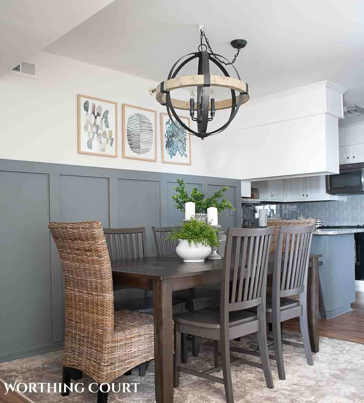 orb shaped chandelier above a gray dining table with wicker head chairs in a beach condo