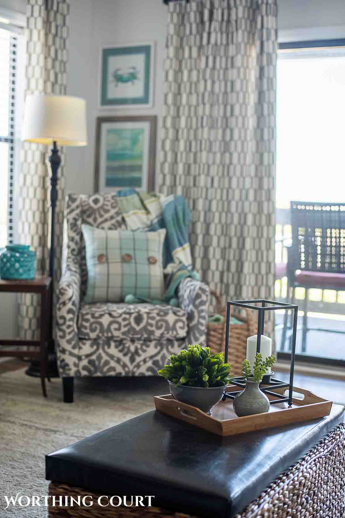 coastal artwork above a gray and white chair in a living room corner