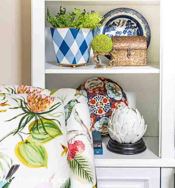 white shelves with summer accessories behind a colorful chair