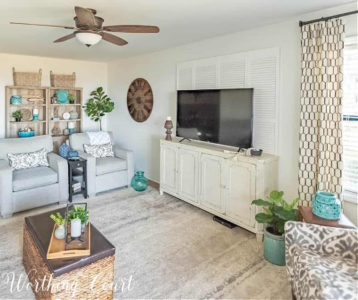 coastal style living room with gray chairs, white tv console and beachy accessories