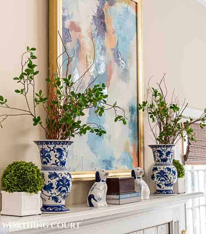 angled view of a mantel with abstract art and blue and white decor