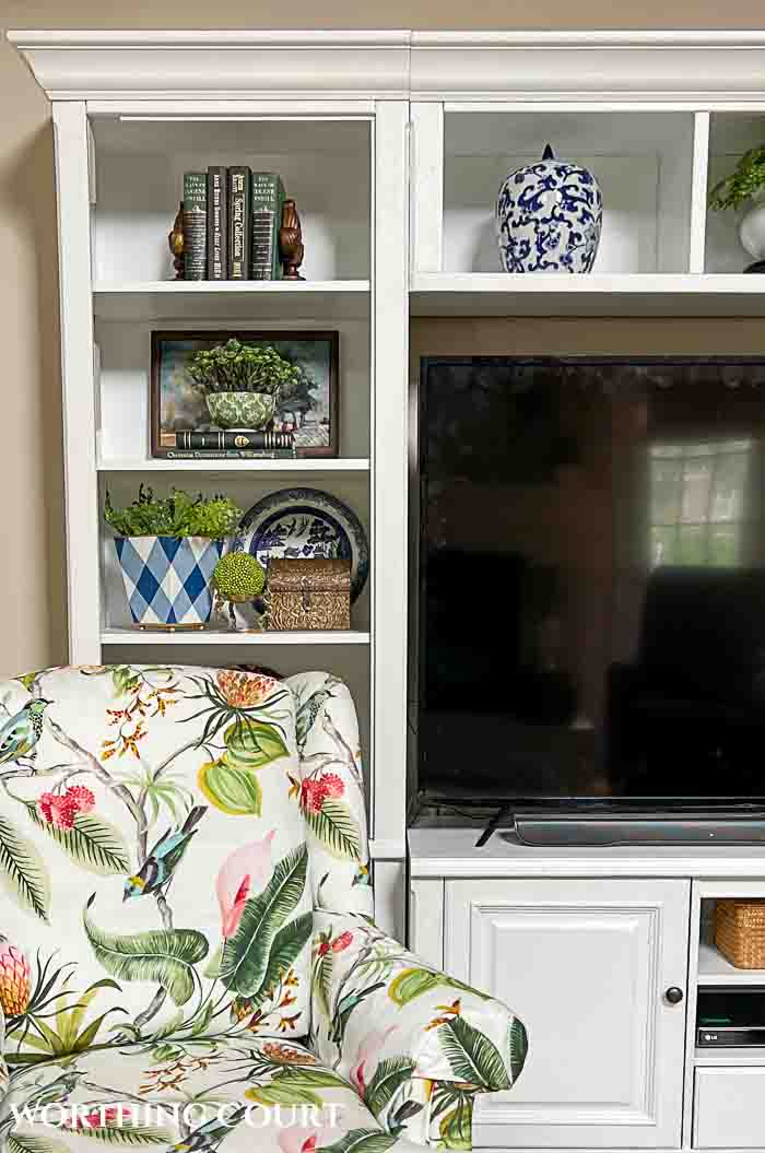 floral chair in front of white entertainment center with accessories