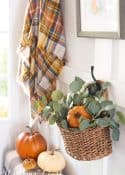 basket filled with fall greenery and pumpkins