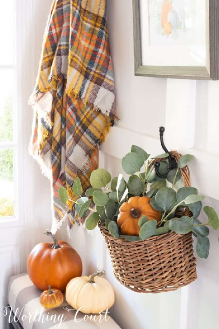 basket filled with fall greenery and pumpkins