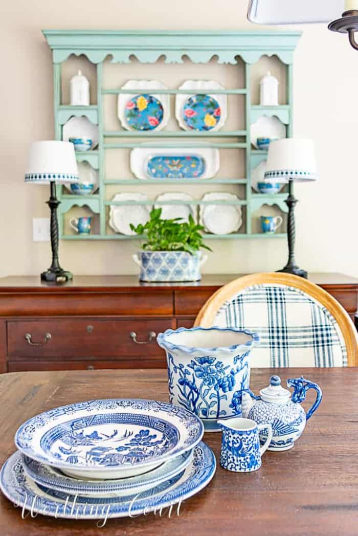 blue and white dishes on a brown table with plate rack in the background