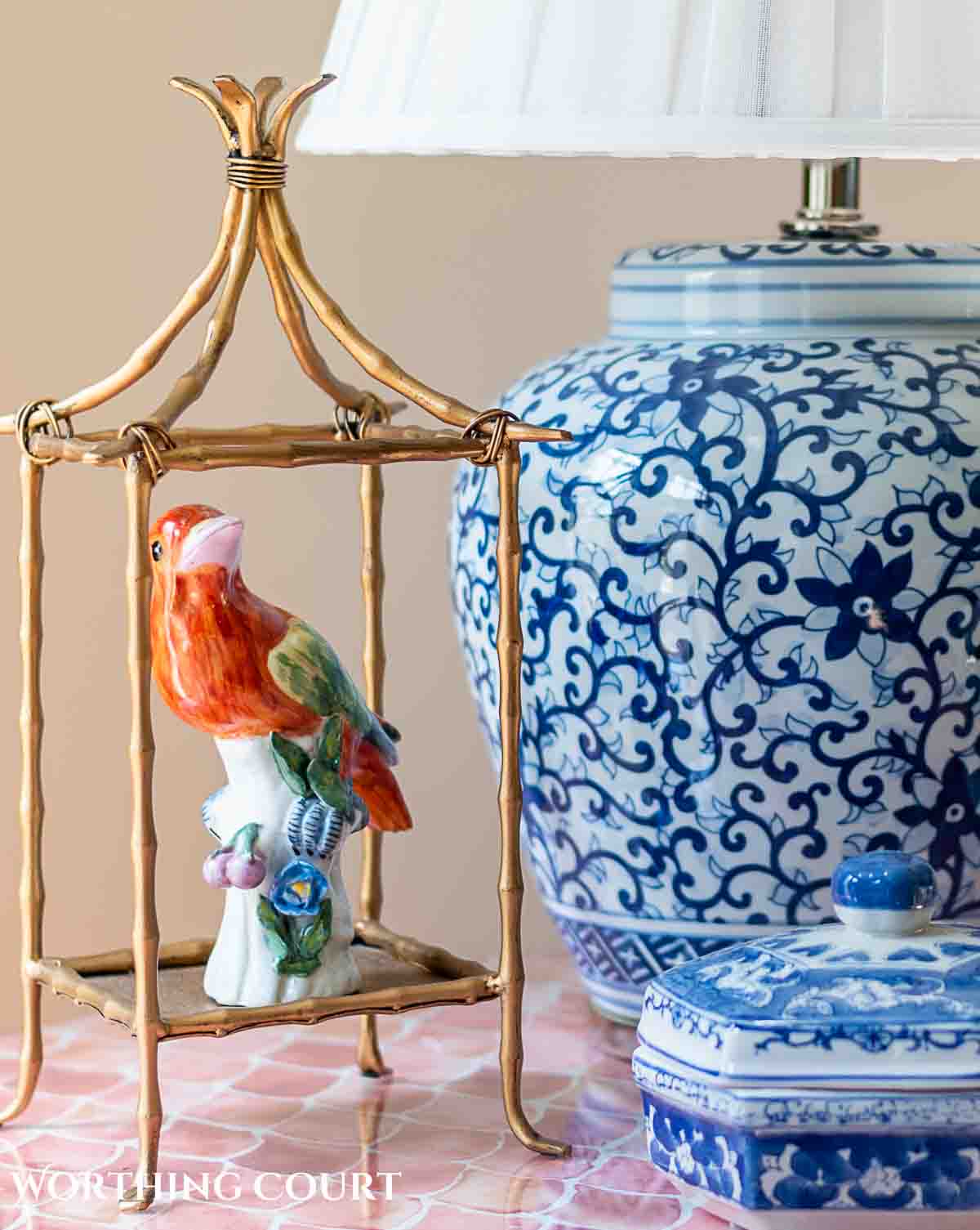 bird figurine in an open brass lantern next to a bue and white lamp
